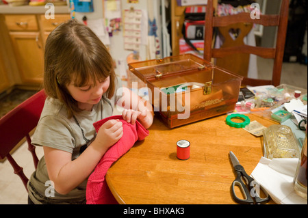 7 year old girl learning to sew Stock Photo