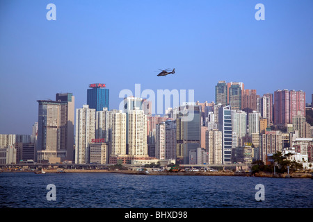 hong kong harbour and city buildings with helicopter overhead Stock Photo