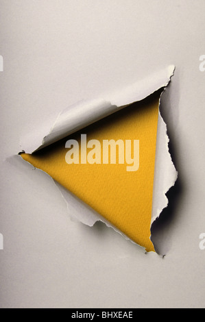 Old ripped paper forming triangle over yellow background Stock Photo