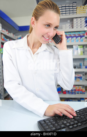 pharmacist at pharmacy talking on phone and using the computer Stock Photo