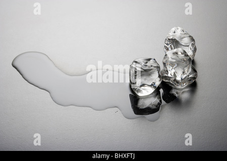 Melting ice cube on a gray background Stock Photo