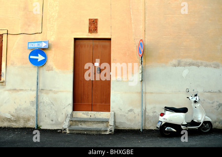 A motor scooter parked in a narrow one-way alleyway in the seaside village of Rinella, on the Aeolian island of Salina, Sicily, Italy. Stock Photo