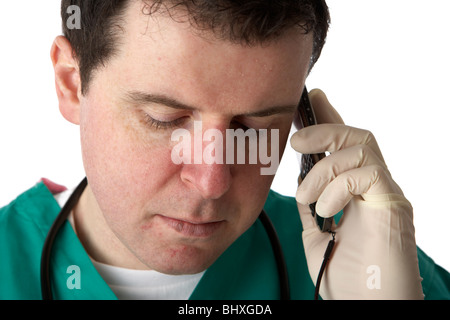 man wearing medical scrubs and stethoscope holding mobile phone to his ear not listening Stock Photo