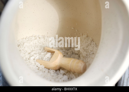 sea salt in container with wooden spoon Stock Photo