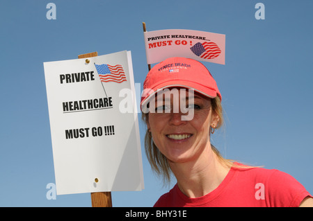 Private healthcare in the USA must go female protester wearing a red hat with flag Stock Photo