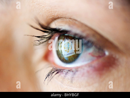 Arabic television channel news service Al Jazeera website logo reflected in womans eye from computer screen Stock Photo