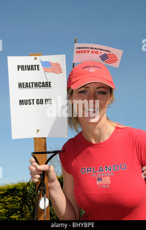Private healthcare in the USA must go female protester holding a stethoscope & protest notices Stock Photo
