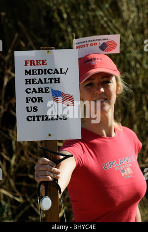 Free healthcare in the USA must go female protester holding a demonstration notice board Stock Photo