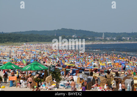 Full of tourists Baltic Sea beach in Swinoujscie, Poland. German Ahlbeck seen on background. Stock Photo