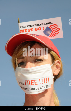 Private healthcare in the USA must go female protester wearing a medical face mask Stock Photo