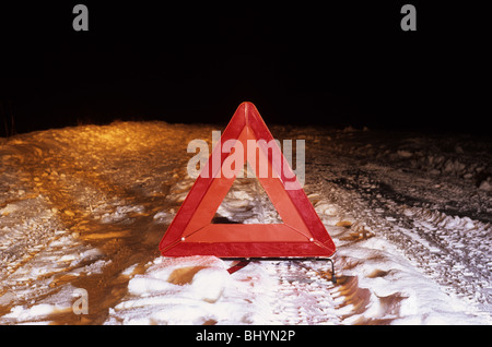 hazard warning triangle on country road in deep winter snow at night near Leeds Yorkshire UK Stock Photo