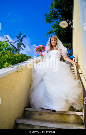 Bride in wedding dress walking down stairs Stock Photo