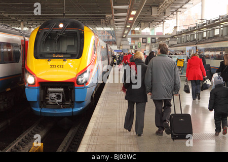 St Pancras railway station London passengers walk past an East Midlands Trains Class 222 Meridian train Stock Photo