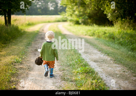 Young boy standing on a gravel road. Stock Photo