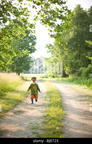 Young boy standing on a gravel road. Stock Photo