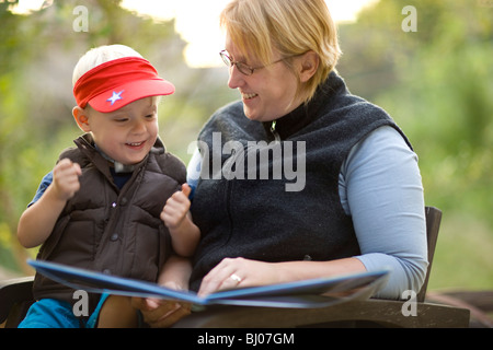 Mother and son reading a book outside. Stock Photo