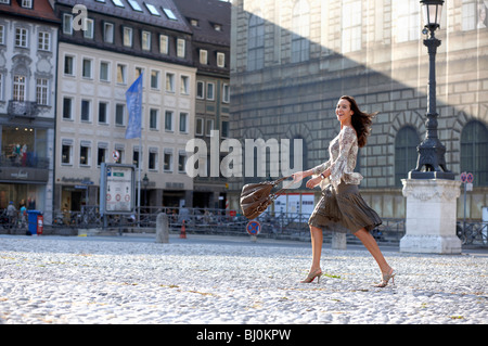 young woman walking over square in city Stock Photo