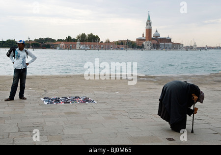 Roma older woman begging  from tourist Venice Italy. North African man selling fake designer sunglasses, 2009 2000s HOMER SYKES Stock Photo