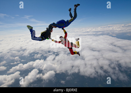 Freefly skydive team is training a special HYBRID formation over a spectacularly cloud scenery in the sky with 130 MpH. Stock Photo