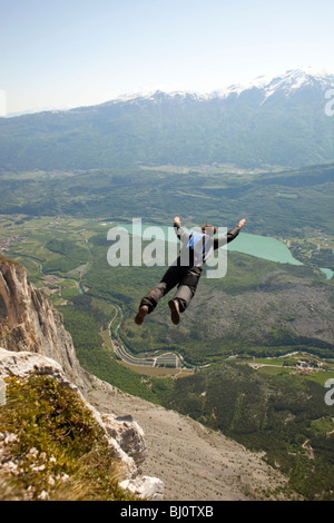 BASE jump from a cliff. The ultimate kick to do an object dive and tracking through the sky along the mountain. Stock Photo