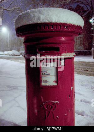 Red Royal Mail letter box at night after heavy snowfalls Stock Photo