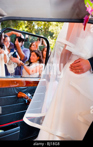 Bride and groom posing for photos near car Stock Photo