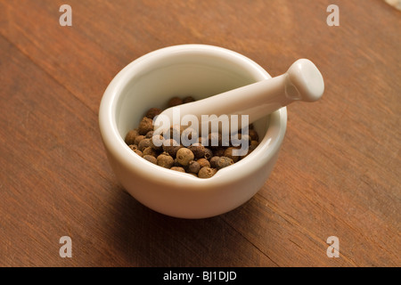 Allspice whole dried berries in a mortar and pestle Stock Photo