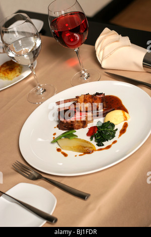 Restaurant table with a plate of lamb meal Stock Photo