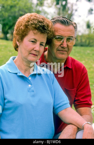 Senior couple serious hug touch think meditate consider thought think outside outdoors sun love Stock Photo