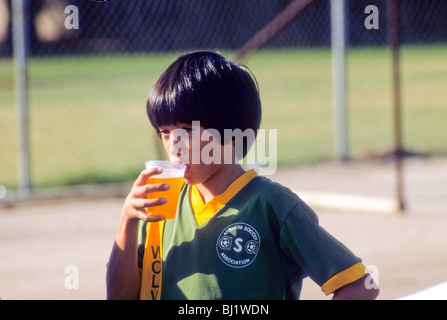 Asian-American boy drinks juice at half-time break during soccer football game in Anaheim, California, USA Stock Photo