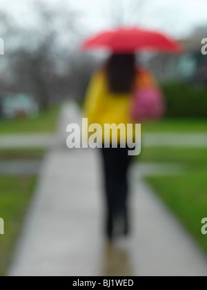 Woman with an umbrella walking along the street on a rainy day Stock ...