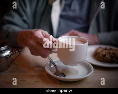 Old ladies hands holding cup of tea. Stock Photo