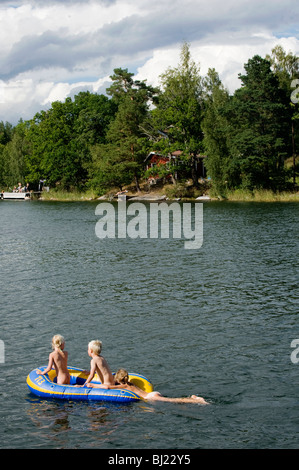 Three children in a rubber boat, Sweden.