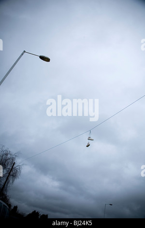 Shoes hanging from telephone line Stock Photo