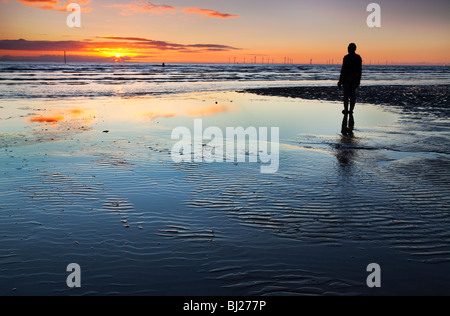 Colouful sunset at Crosby beach, with one Of Anthony Gormly Statues Stock Photo