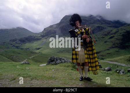 Scottish Piper in traditional dress playing the bagpipes outside Stock ...
