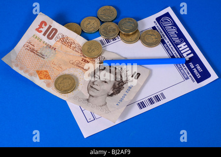 William Hill betting slip with ten pound note and pound coins Stock Photo