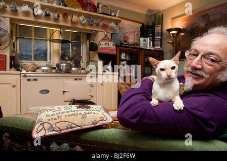 senior man at home with his cat Stock Photo