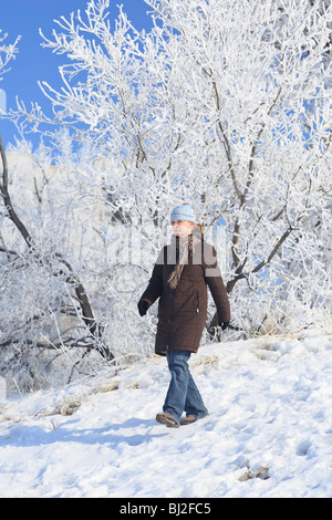 Woman out for a stroll on a frosty winter day.  Sturgeon Creek, Winnipeg, Manitoba, Canada. Stock Photo