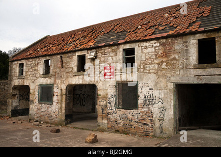 A deserted, run-down building in a state of disrepair. A sign on the wall reads 'No Access for Troops' Stock Photo