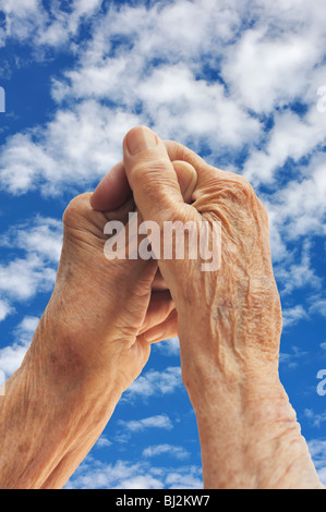 Senior woman's hands over sky