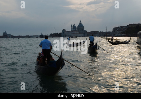 Venice Italy . Tourists gondola rides. The church of Santa Maria della Salute in background. Stock Photo