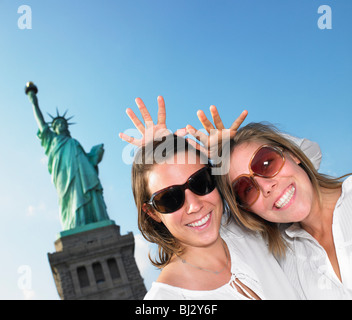 Women imitating Statue of Liberty Stock Photo