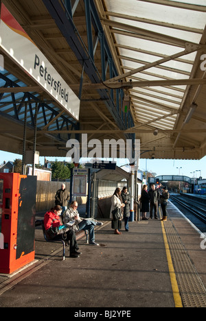 Passengers waiting for train on Petersfield railway station platform Stock Photo