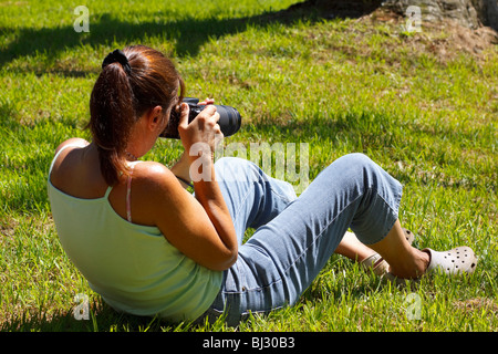 Female nature photographer framing a shot with a zoom lens. Kwazulu Natal, South Africa. Stock Photo