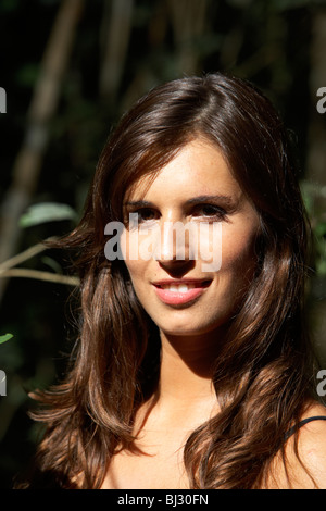 young hispanic latin woman with long dark hair smiling in forest area of argentina south america Stock Photo