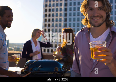 friends on roof top in city having BBQ Stock Photo
