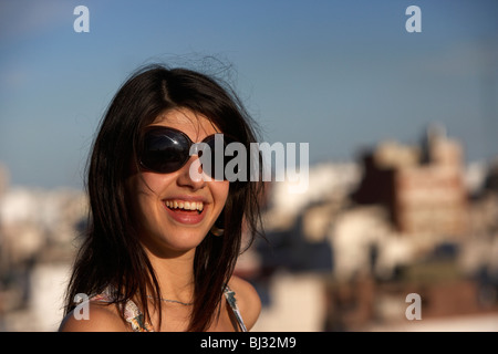 young hispanic latin woman laughing wearing sunglasses with buenos aires city in the background argentina Stock Photo