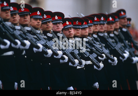 Passing out parade of seventeen officer cadets marching in full dress uniform with their rifles on shoulders at Sandhurst. Stock Photo