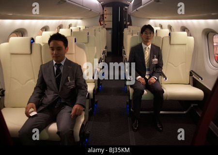 Two employees of the Japanese aircraft manufacturer Mitsubishi sit in a full-scale model of their MRJ at the Paris Air Show. Stock Photo